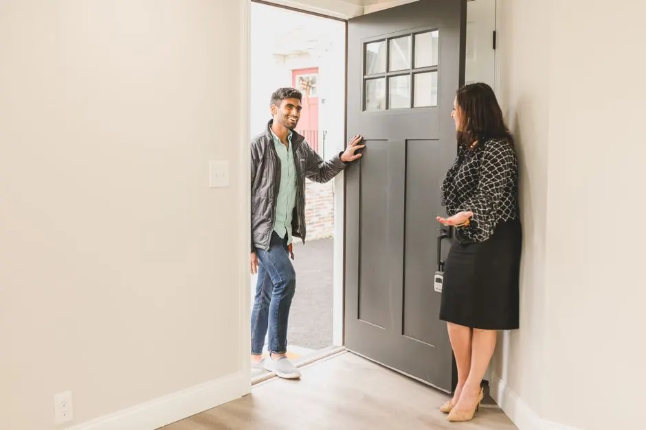 Agente immobilière accueillant un client dans un bien en vente